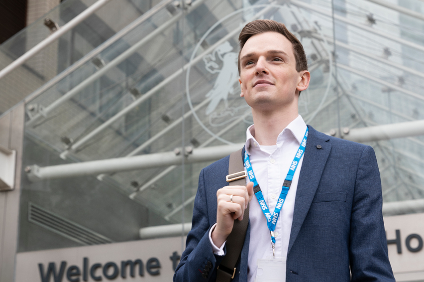 Image of a person with a hospital in the background