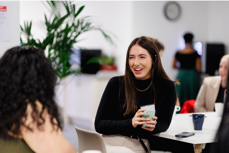 Trainee chatting to another trainee in a work environment